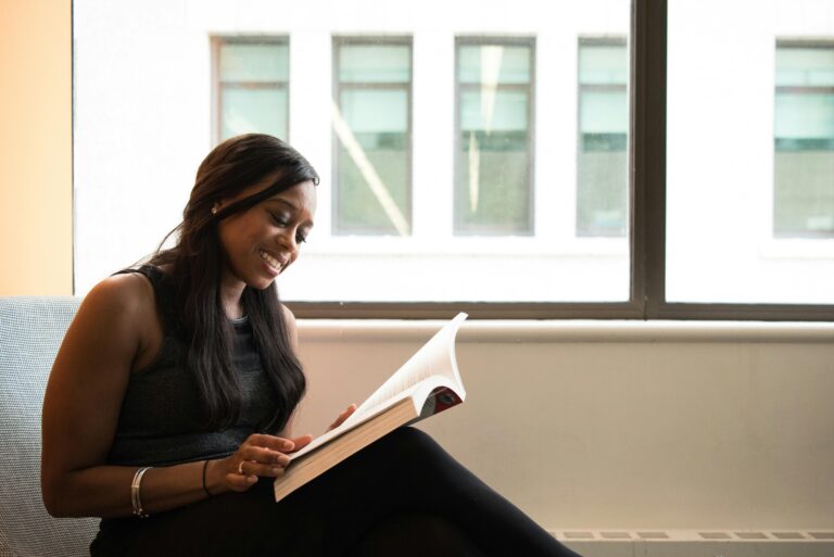 A woman sitting on a couch, engrossed in a book